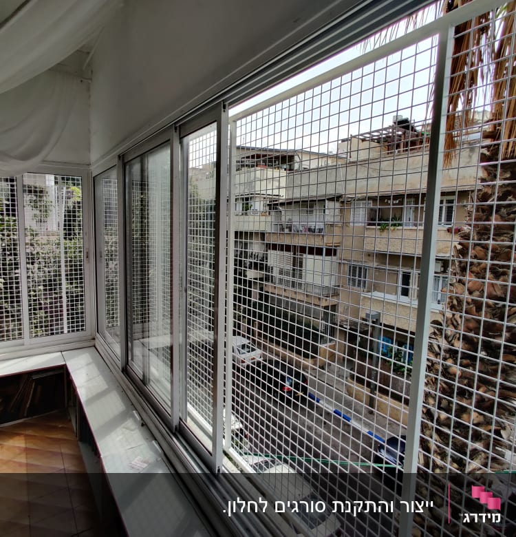 חלונות עם מסגרות מתכת ורשתות במרפסת סגורה